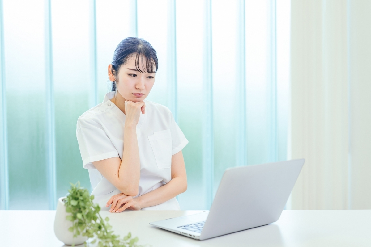 パソコンを見ながら悩む看護師
