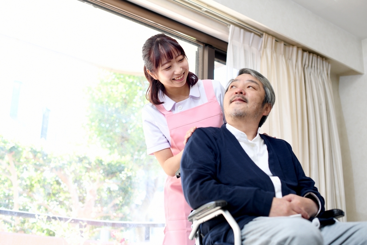 車いすの男性を介助する女性