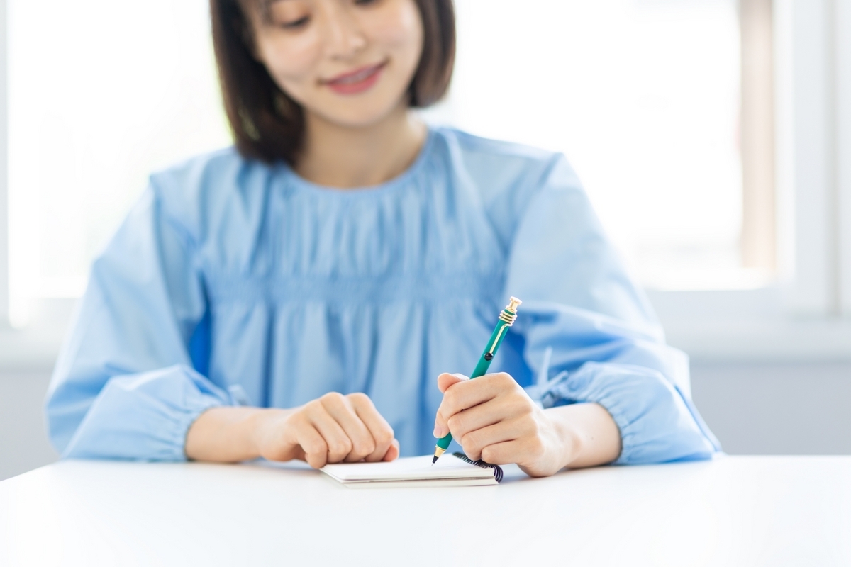 ノートに書き込む女性