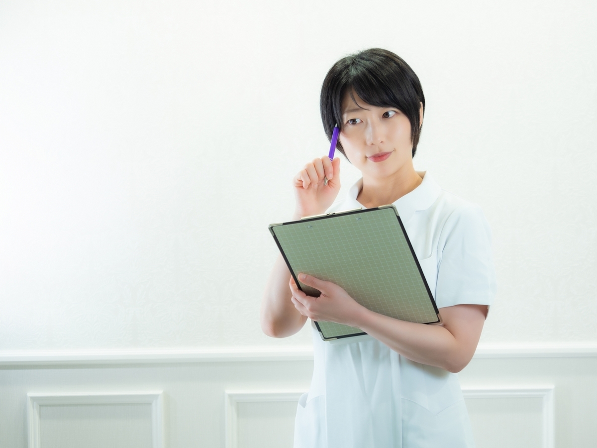 カルテを見ながら考えている看護師