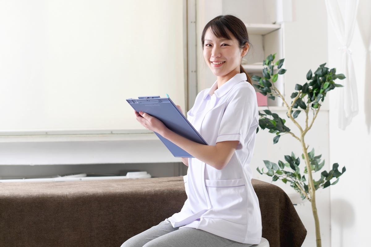 カルテをつける白衣の女性