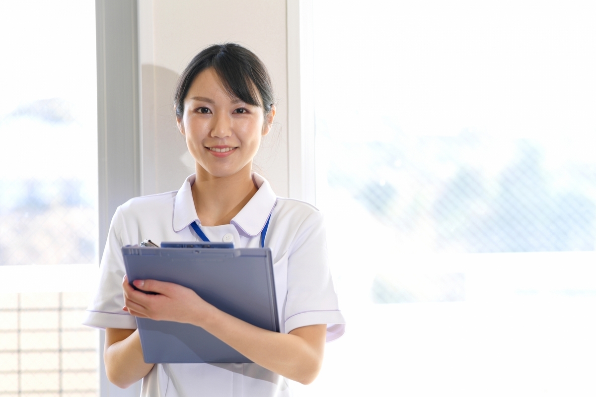 カルテを持っている白衣の女性