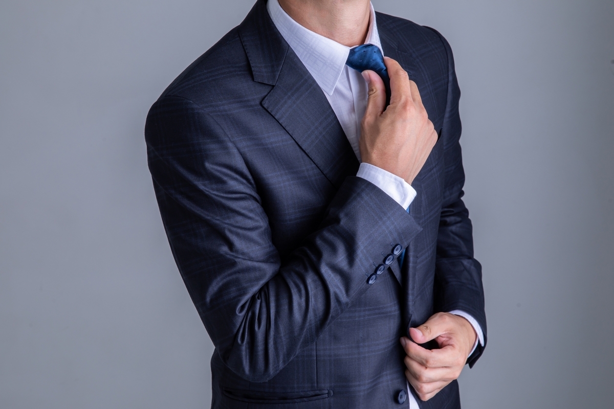 ネクタイを整えるスーツの男性