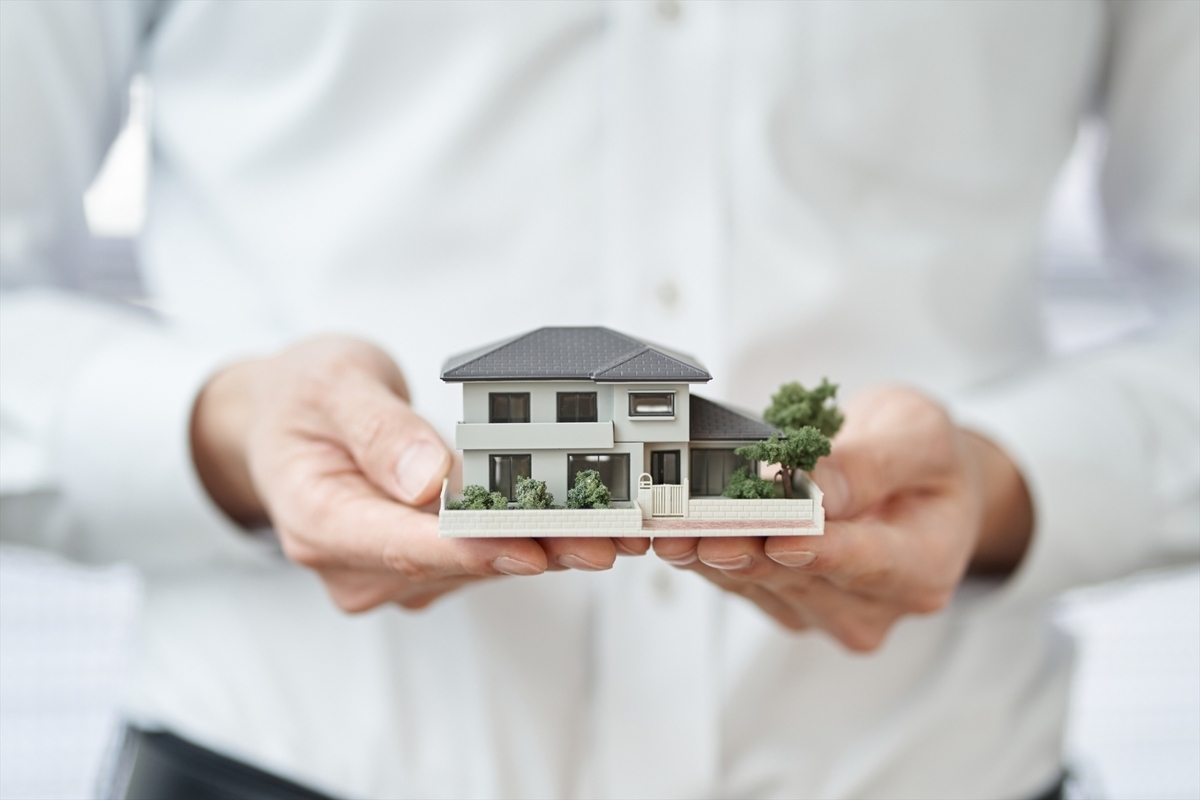 家の模型を持っている手