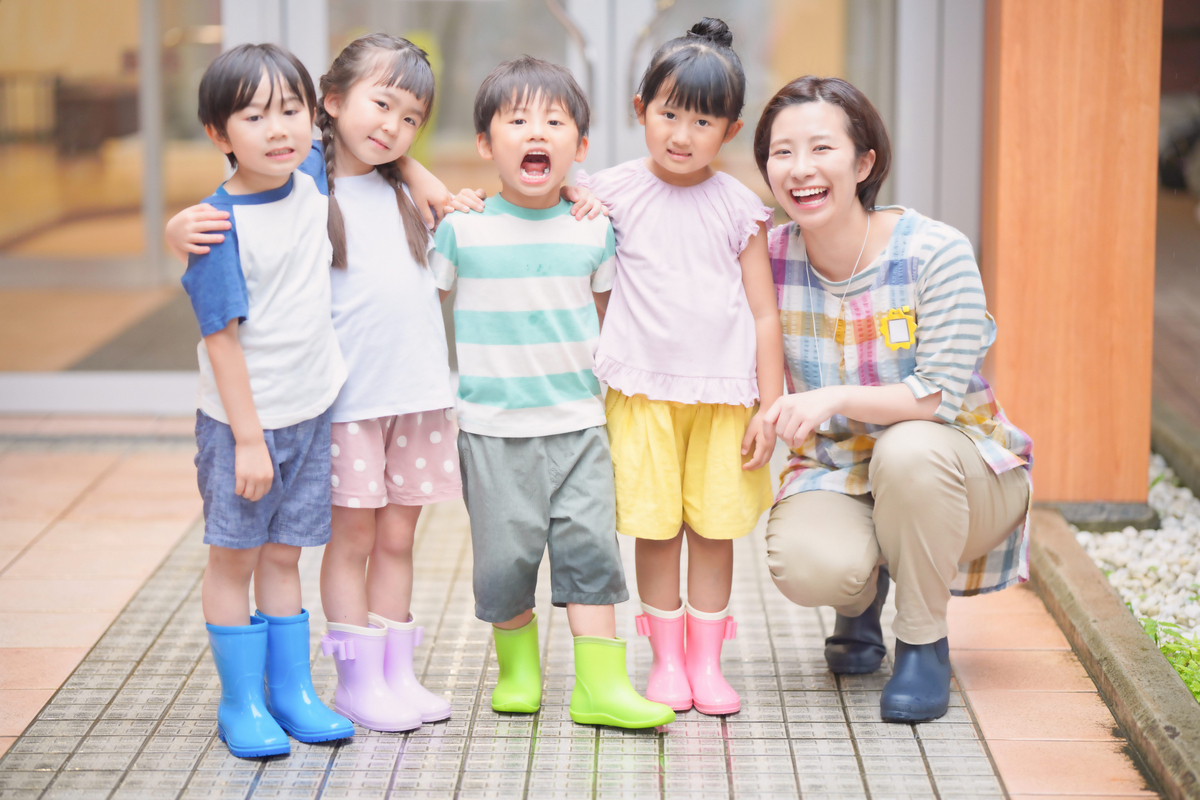 並んでいる子供たちと保育士の女性