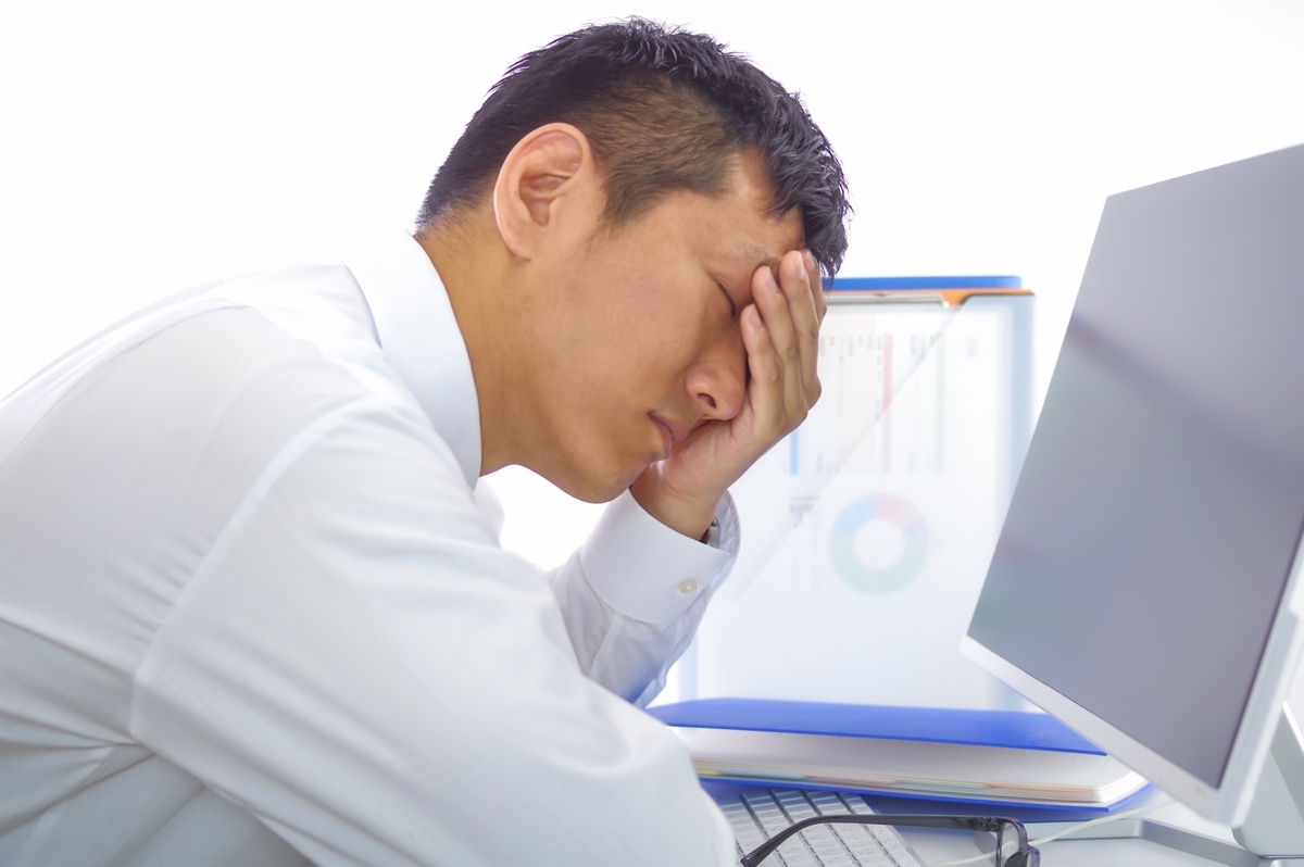 パソコンを前に疲れている男性