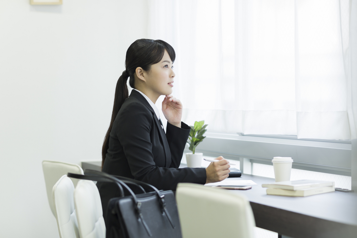 考え事をする就活生の女性