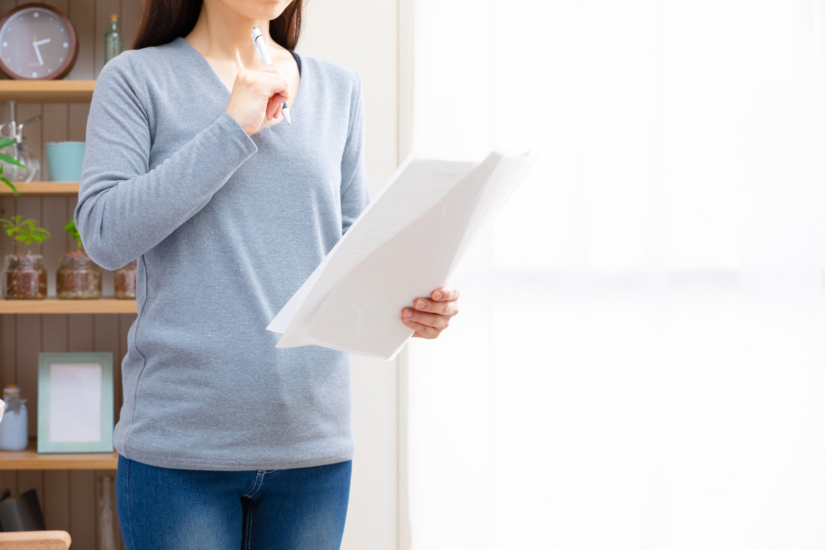 履歴書を手にして考える女性