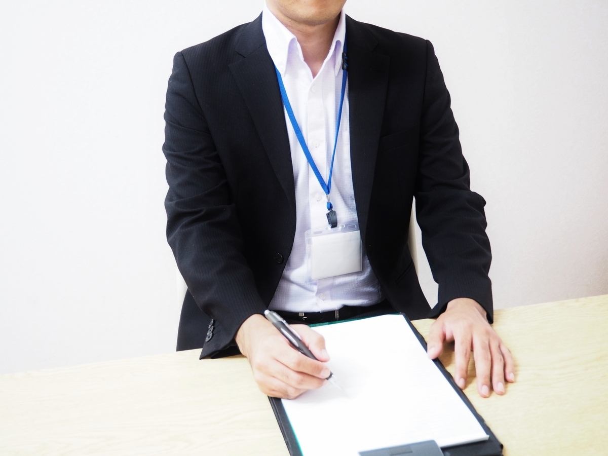 バインダーに記入する男性社員