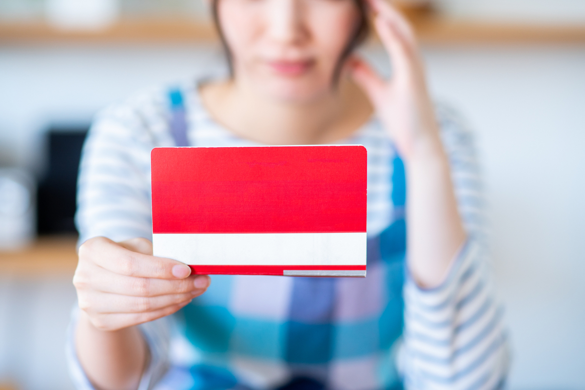 通帳を見ながら考える女性