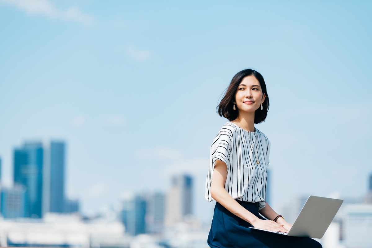 屋外でパソコンを操作する女性
