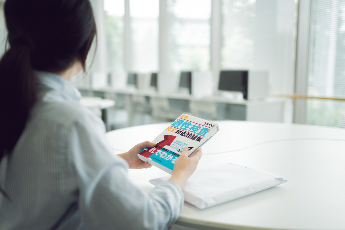 テキストを手にしている女性