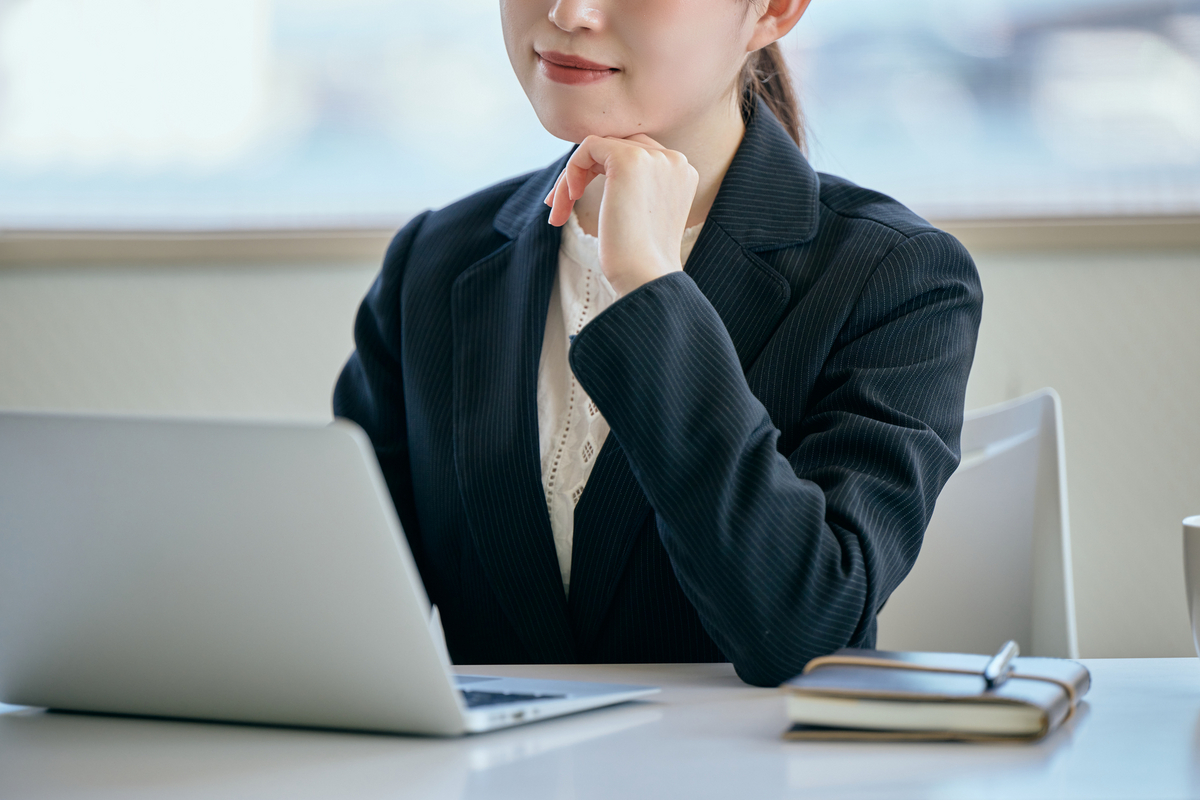 パソコンを前に考え事をする女性