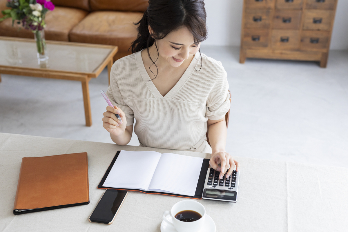 電卓を打ちながら記録する女性