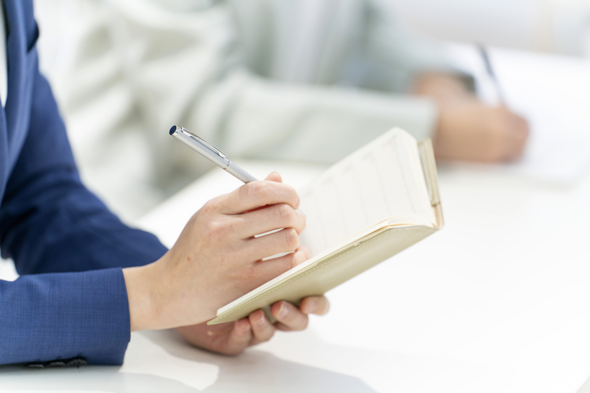 手帳に記入する手元