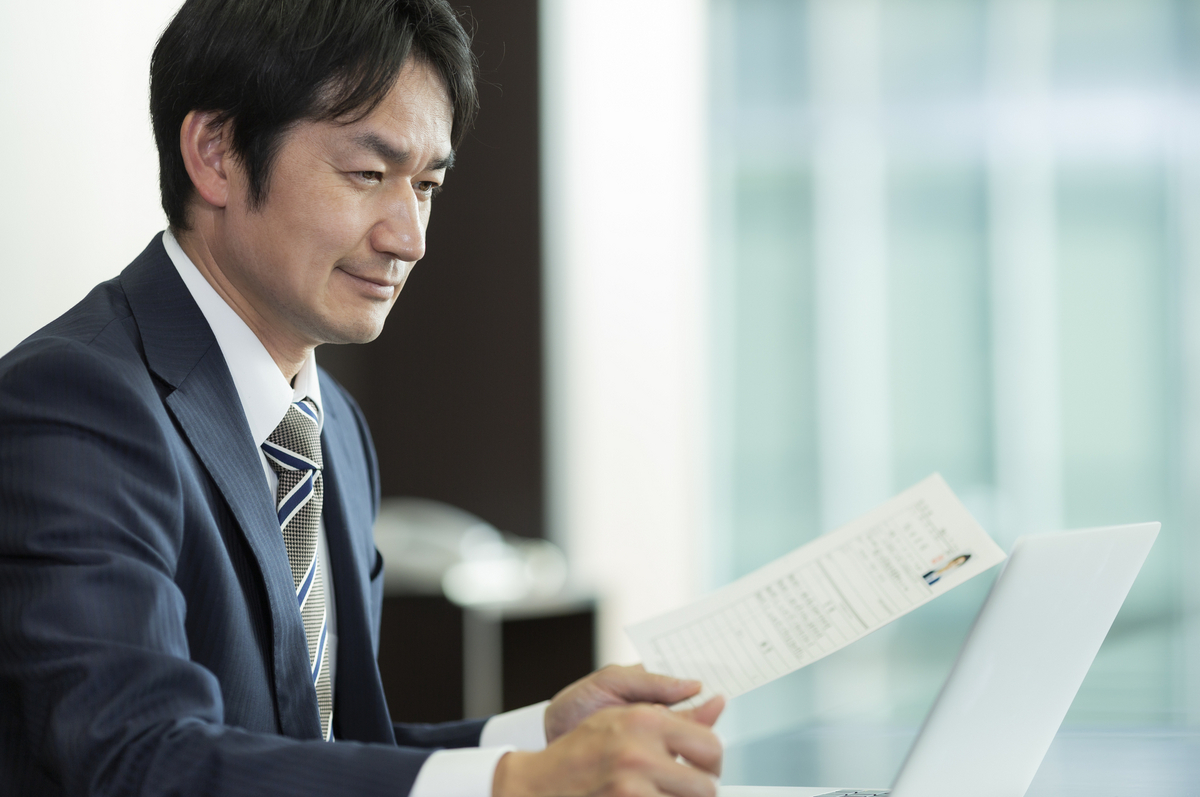 履歴書を見ている男性