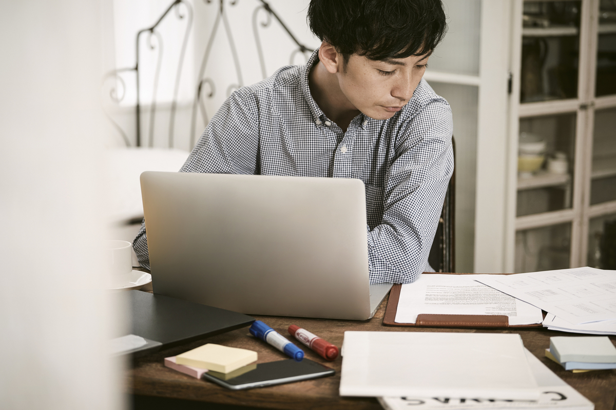 資料を見ながらパソコンを操作する男性