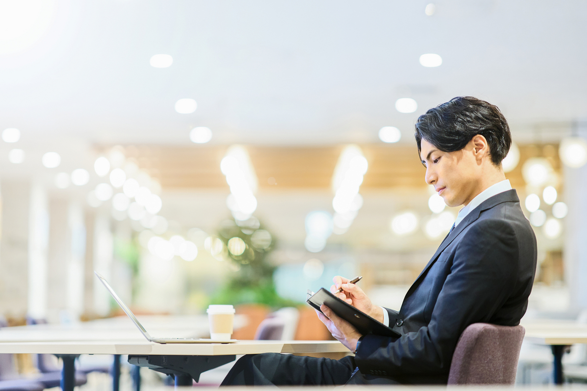手帳に記入する男性