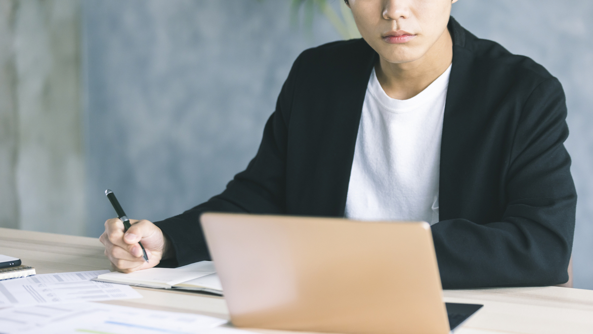 パソコンを見ながら書き込む男性