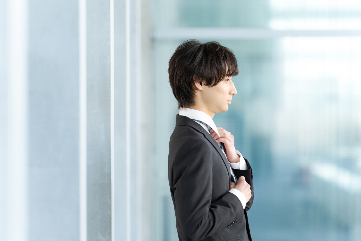 ネクタイを整える男性
