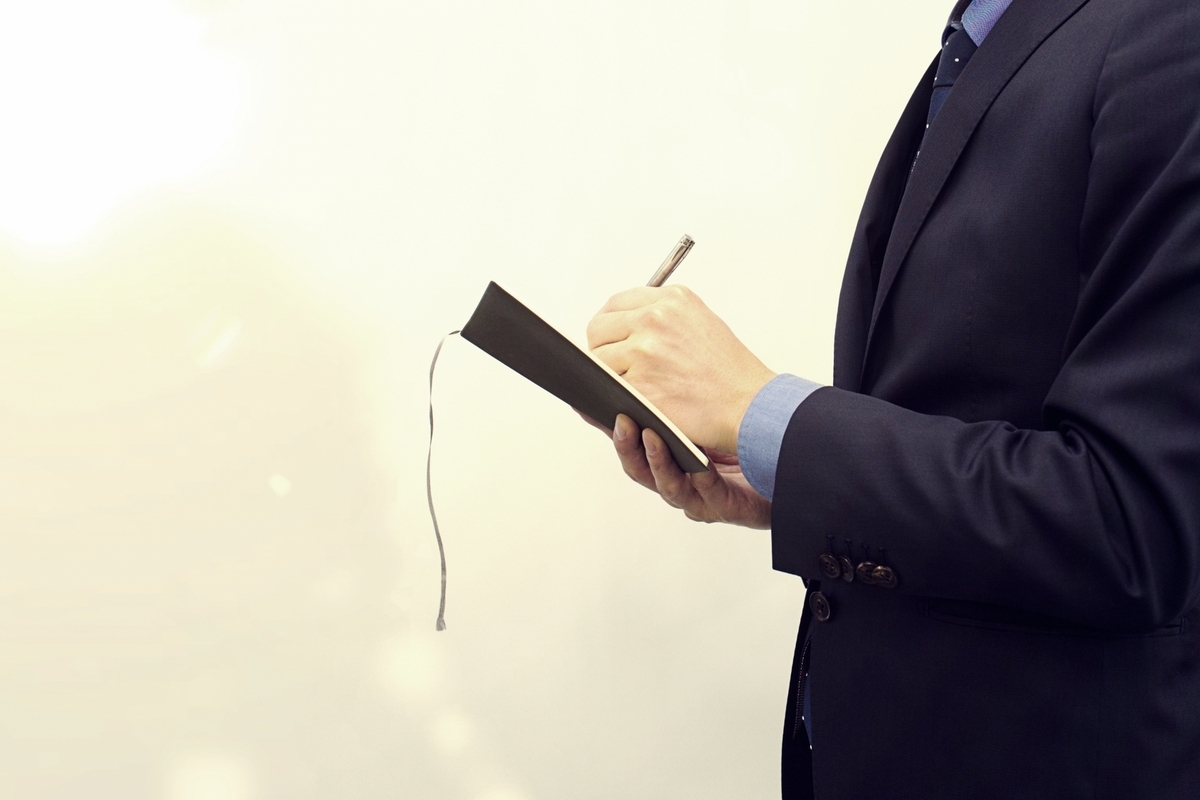 手帳に書き込む男性