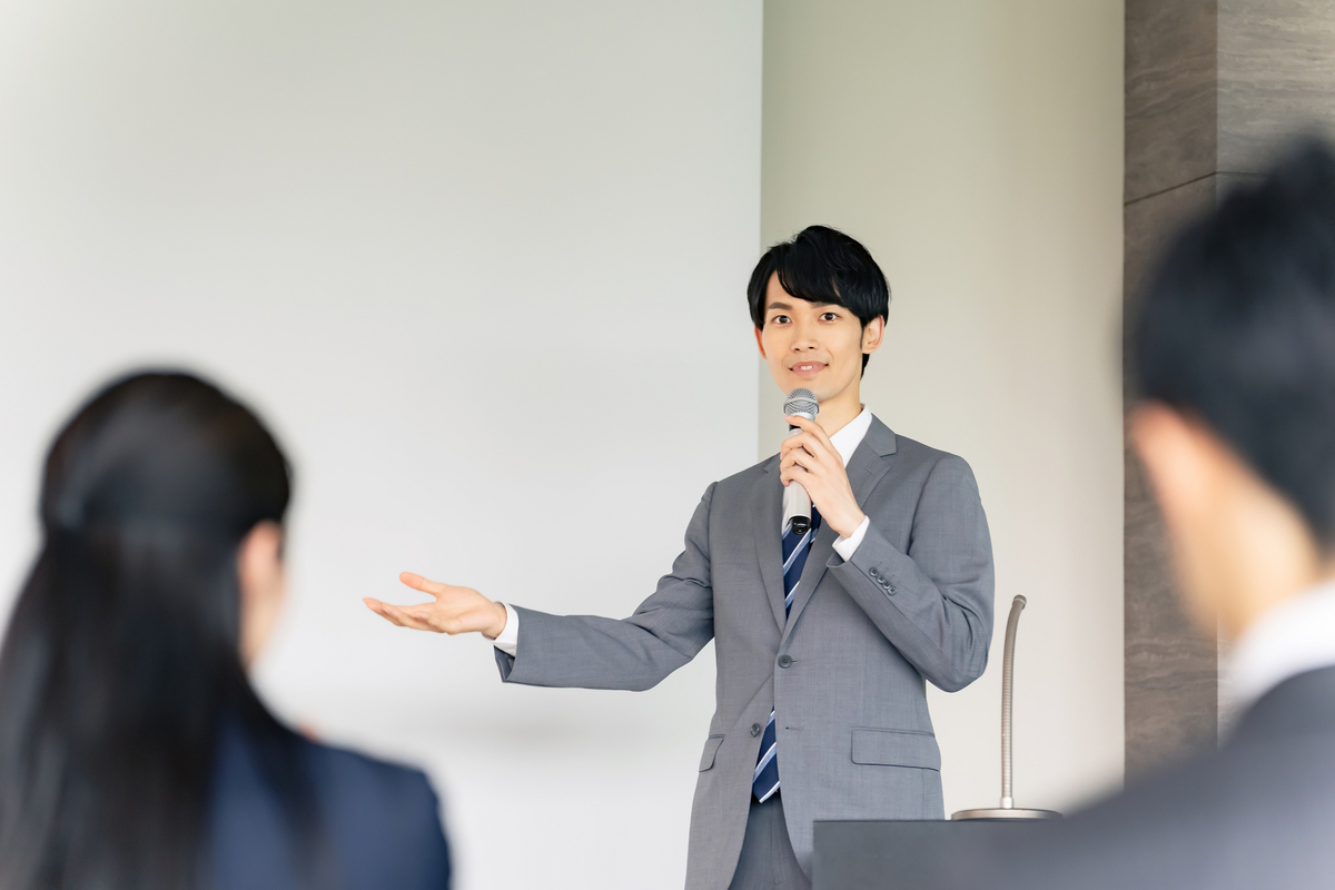 マイクを手に話す男性
