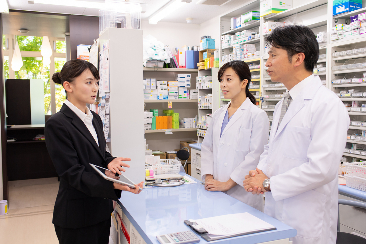 薬局で話すスーツの女性