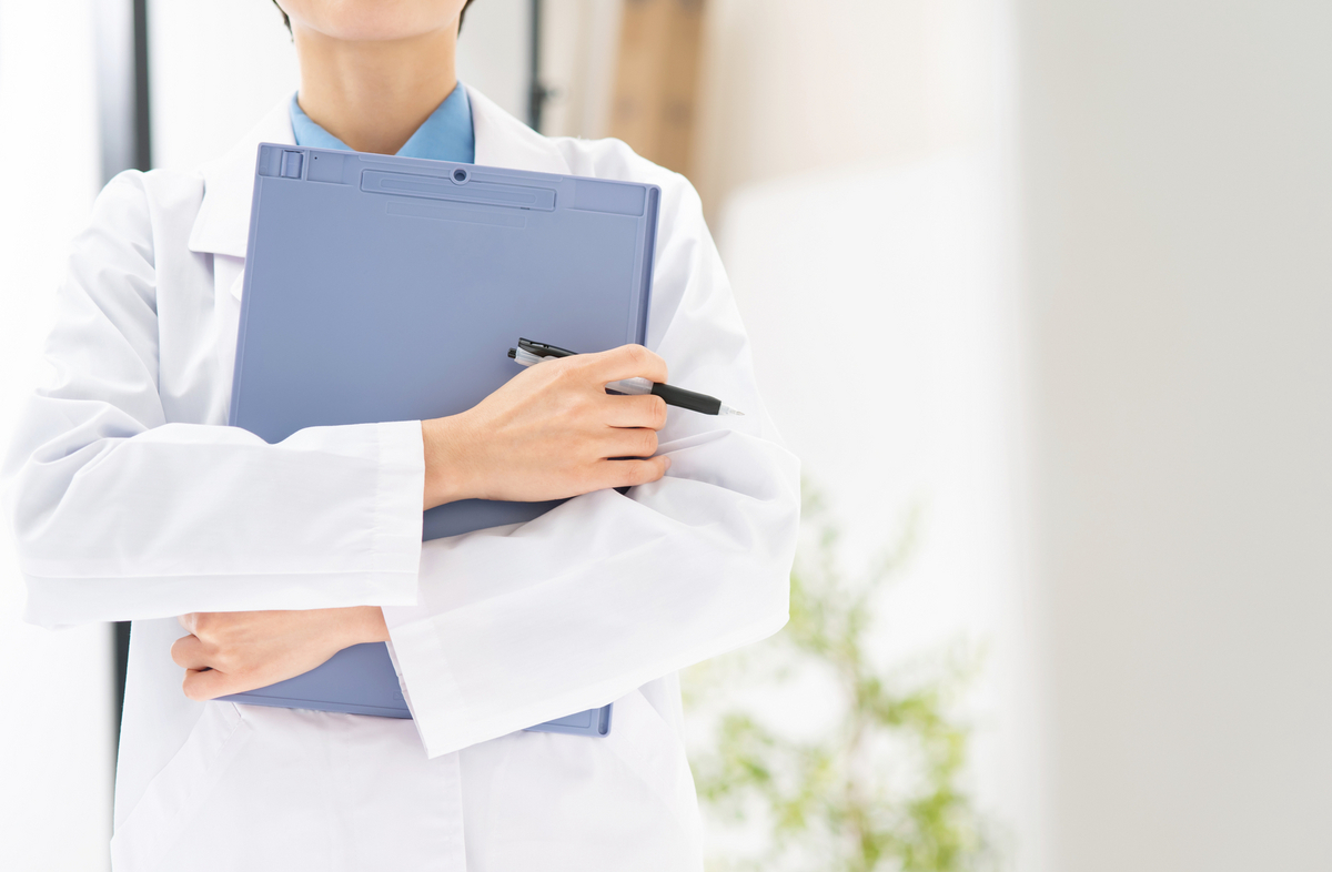 カルテを持っている白衣の女性