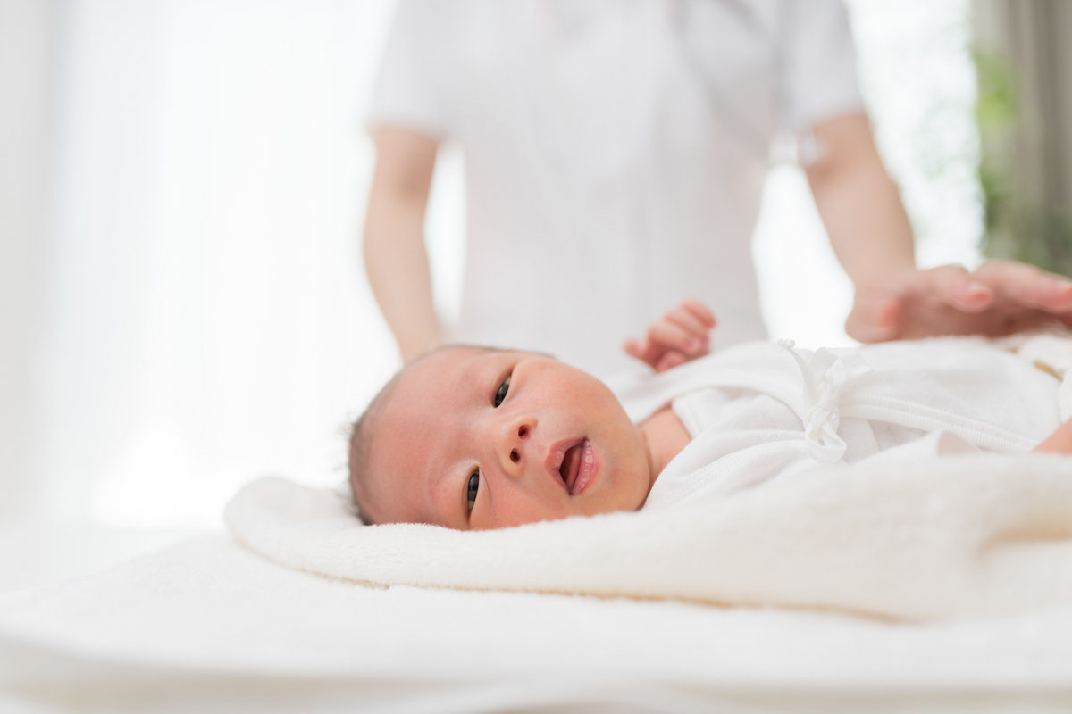 新生児を寝かせる看護師