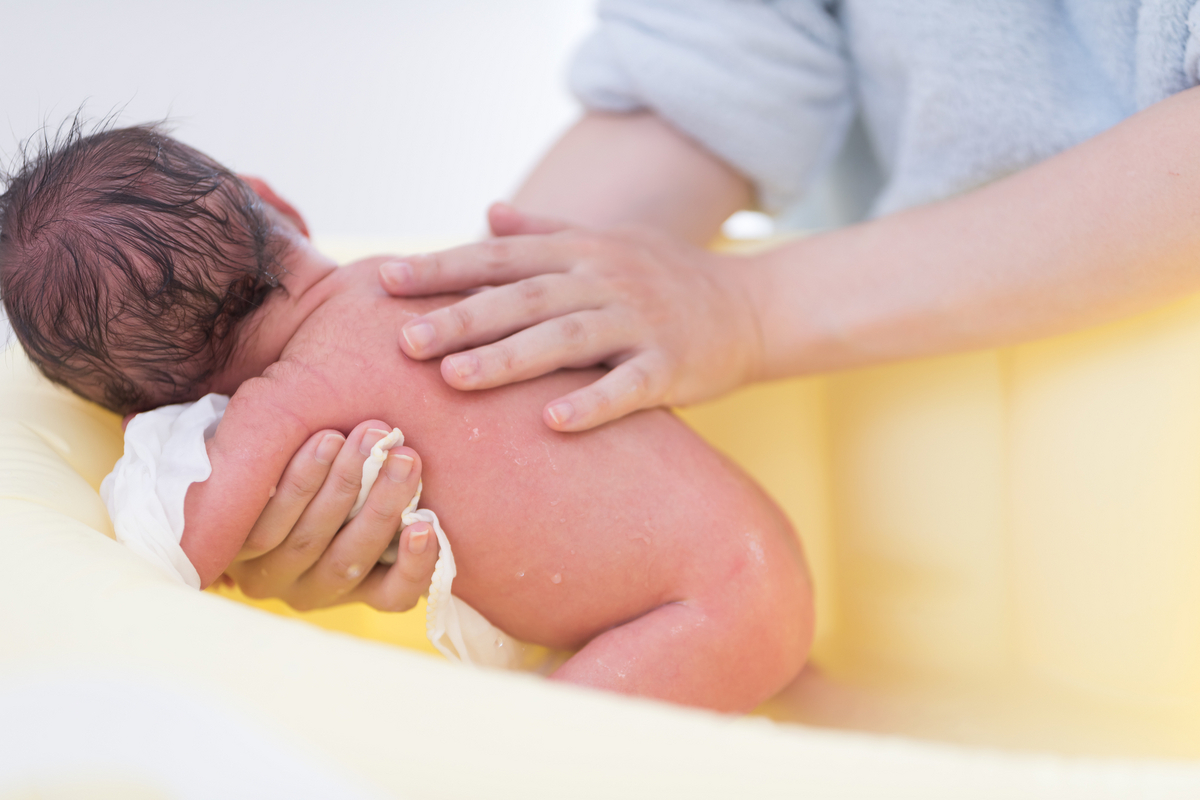 新生児を洗う助産師