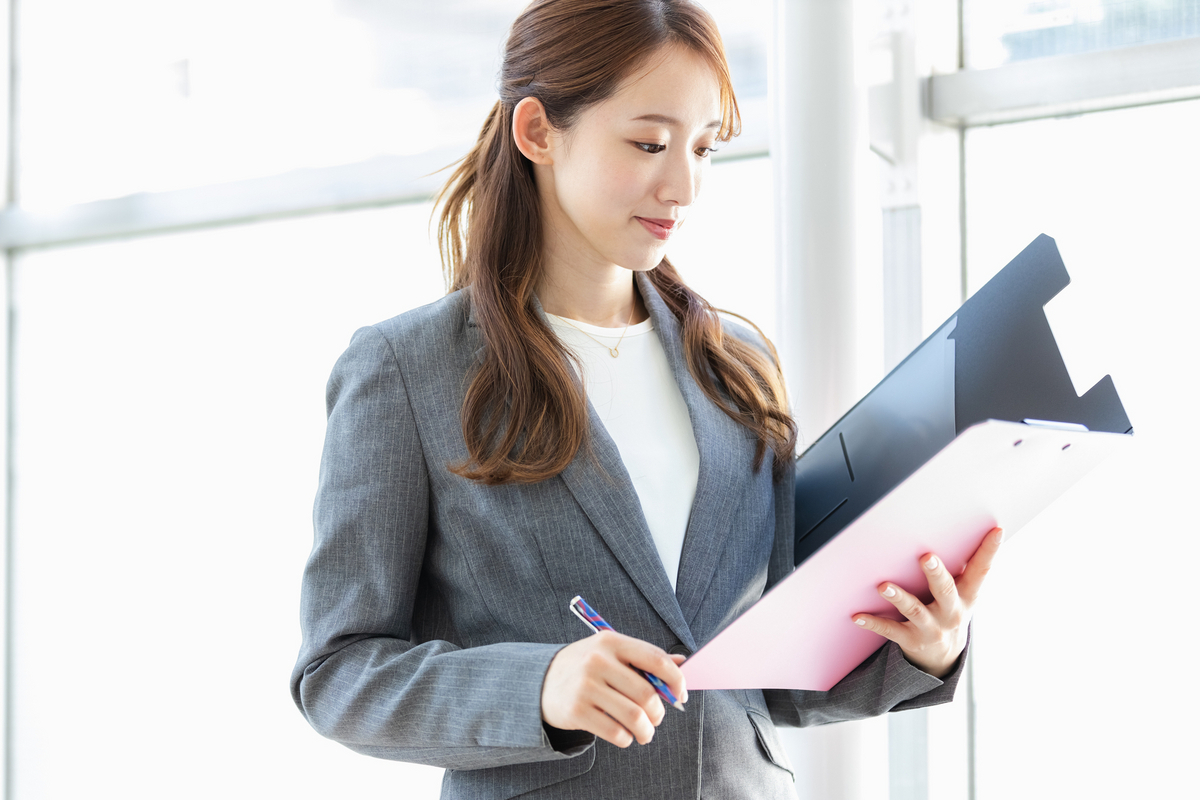 バインダーを手にしている女性