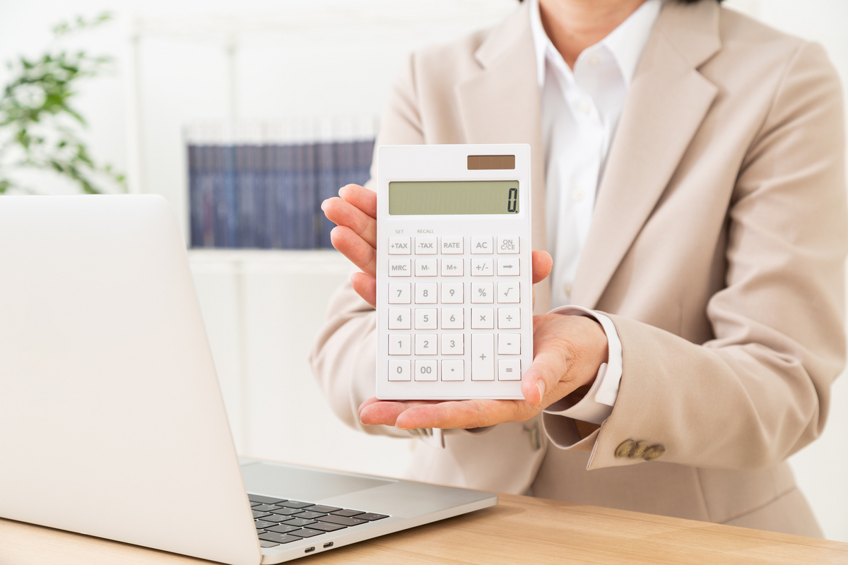 電卓を手にしているスーツの人物