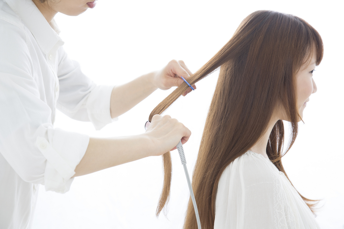 女性の髪を切る