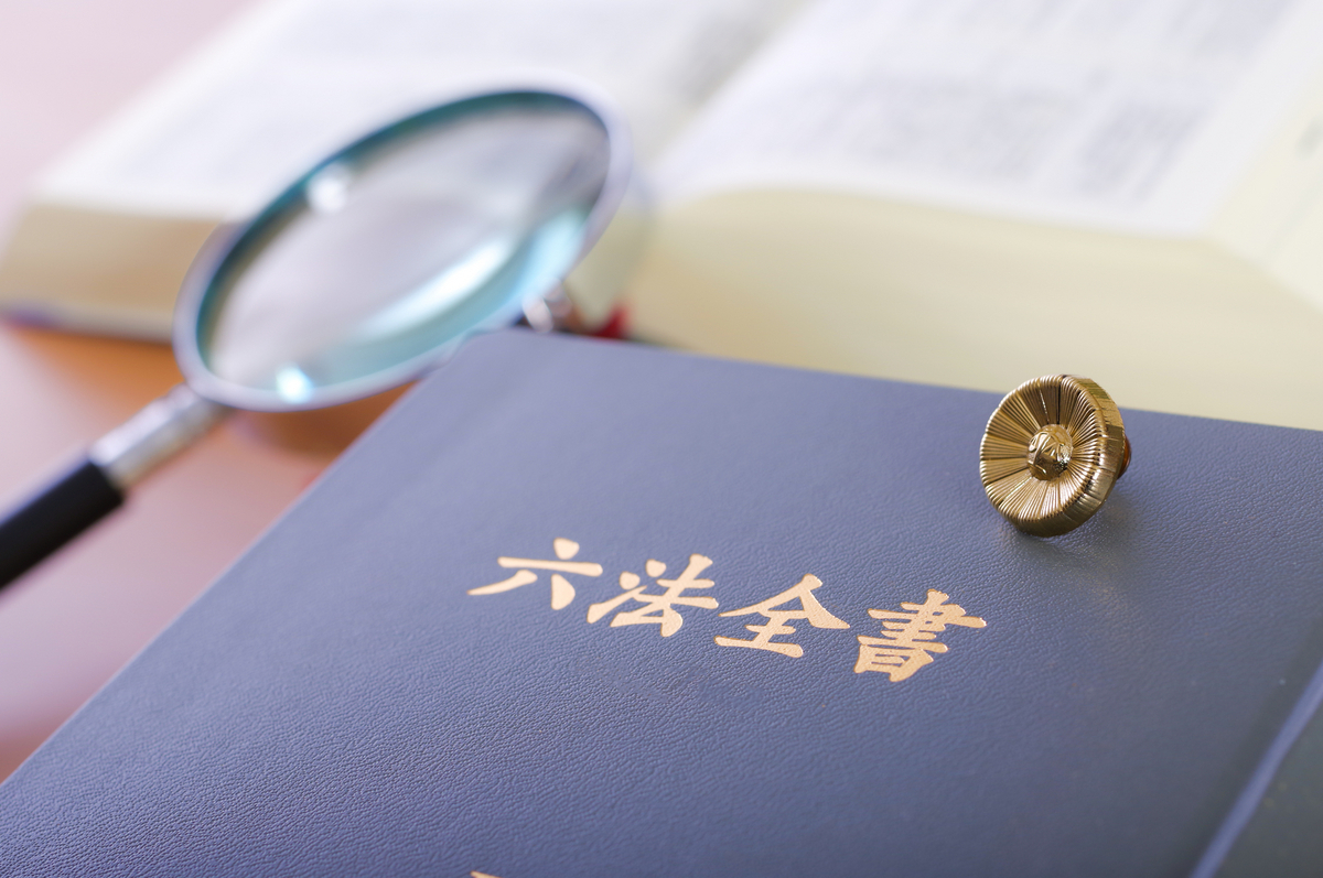 六法全書と弁護士バッジ