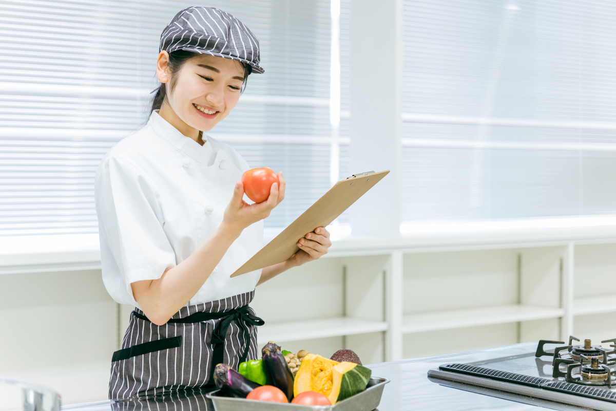 トマトを手にする女性栄養管理士