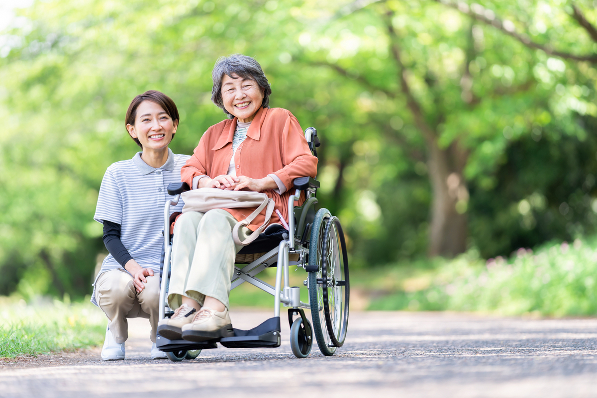 車いすの高齢者と介護士