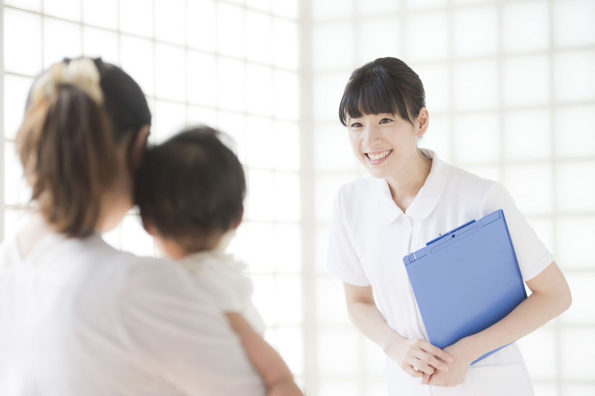 子供とあいさつする白衣の女性