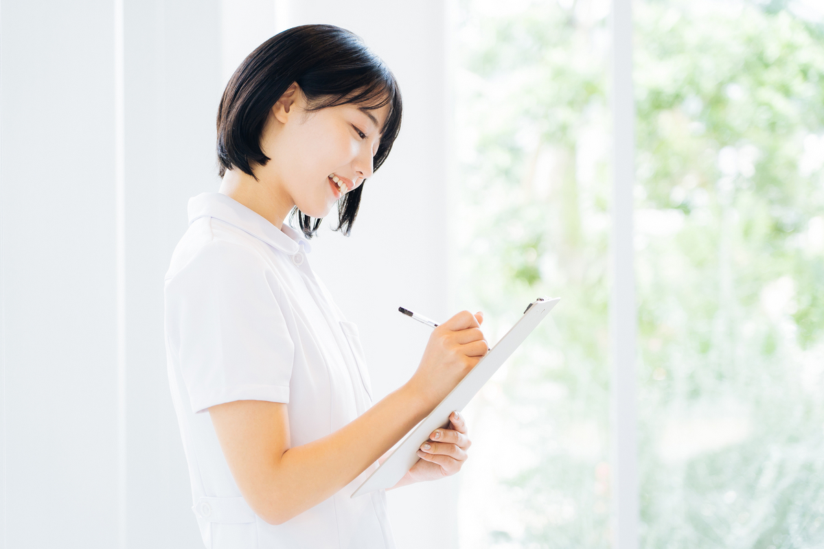 カルテに書き込む白衣の女性