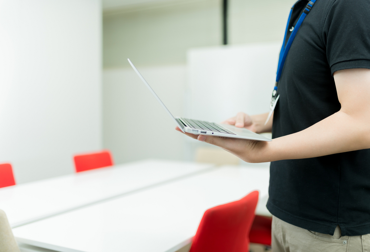 パソコンを手にしている男性