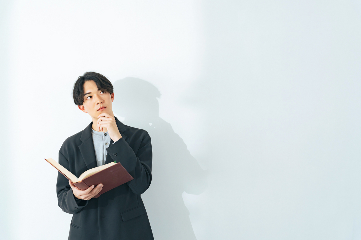 本を手に考える男性