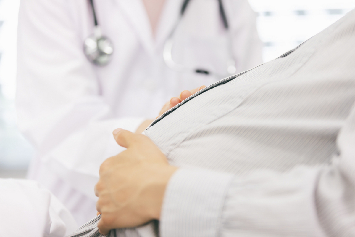 妊婦のおなかをさする医師