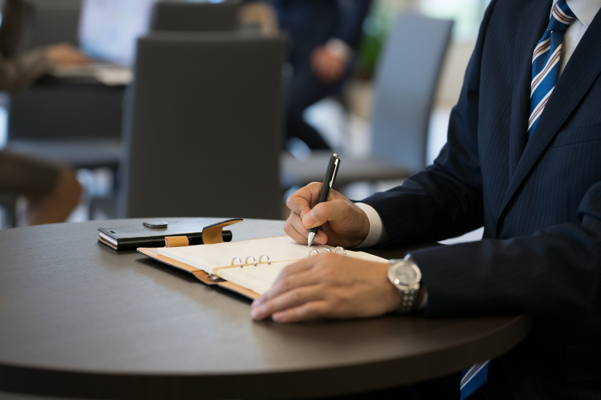 手帳に書き込む男性