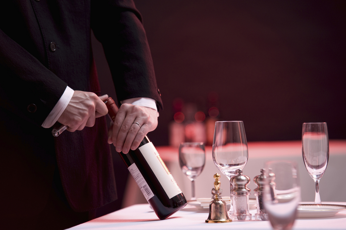 ワインの栓を抜くソムリエ