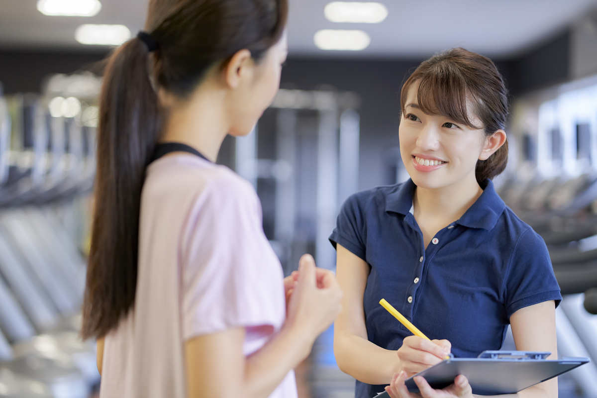 女性と話す事務のインストラクター
