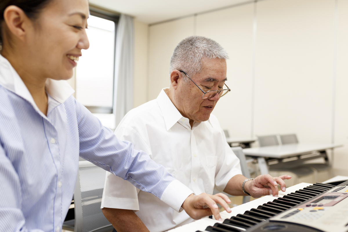 ピアノを弾く女性と高齢者