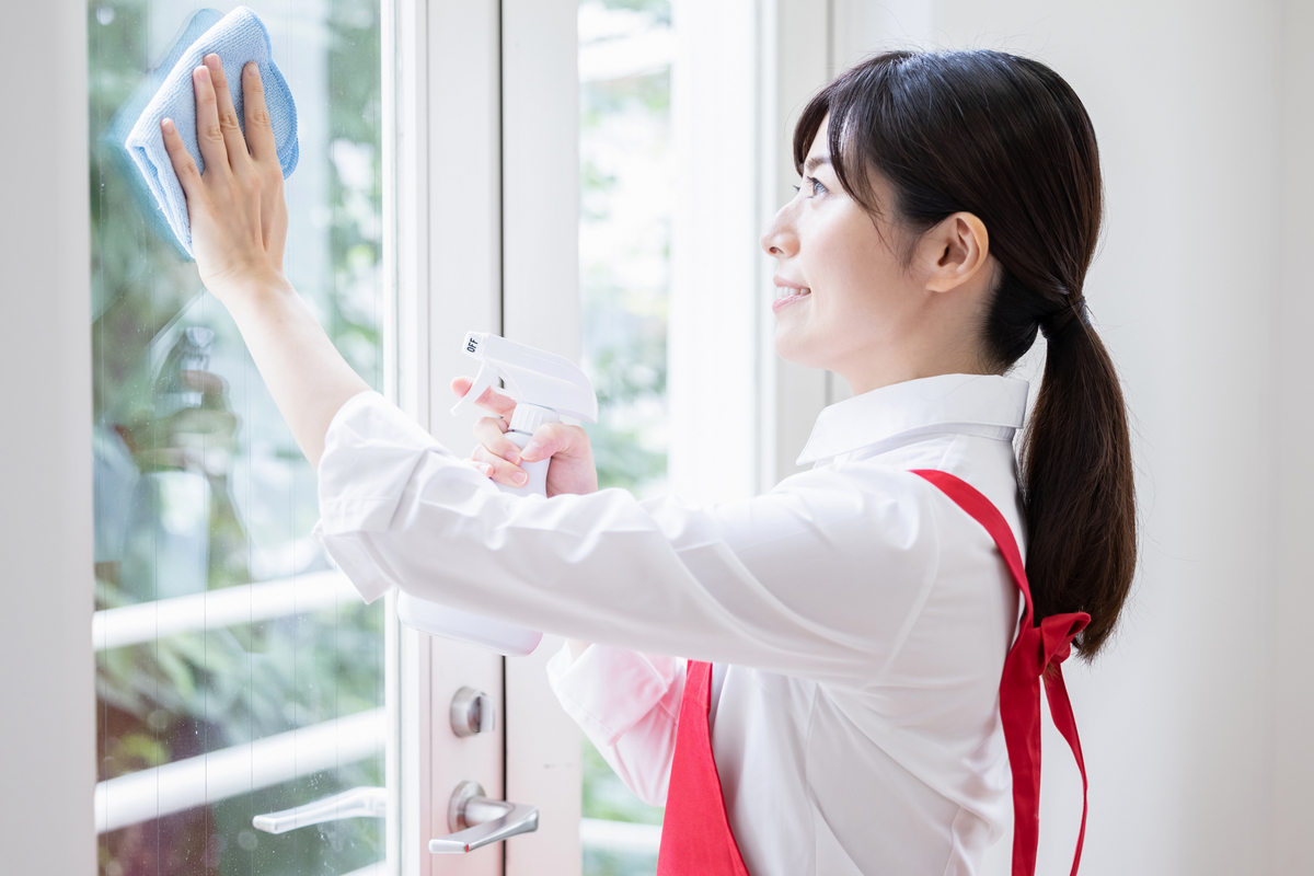 窓を掃除する女性