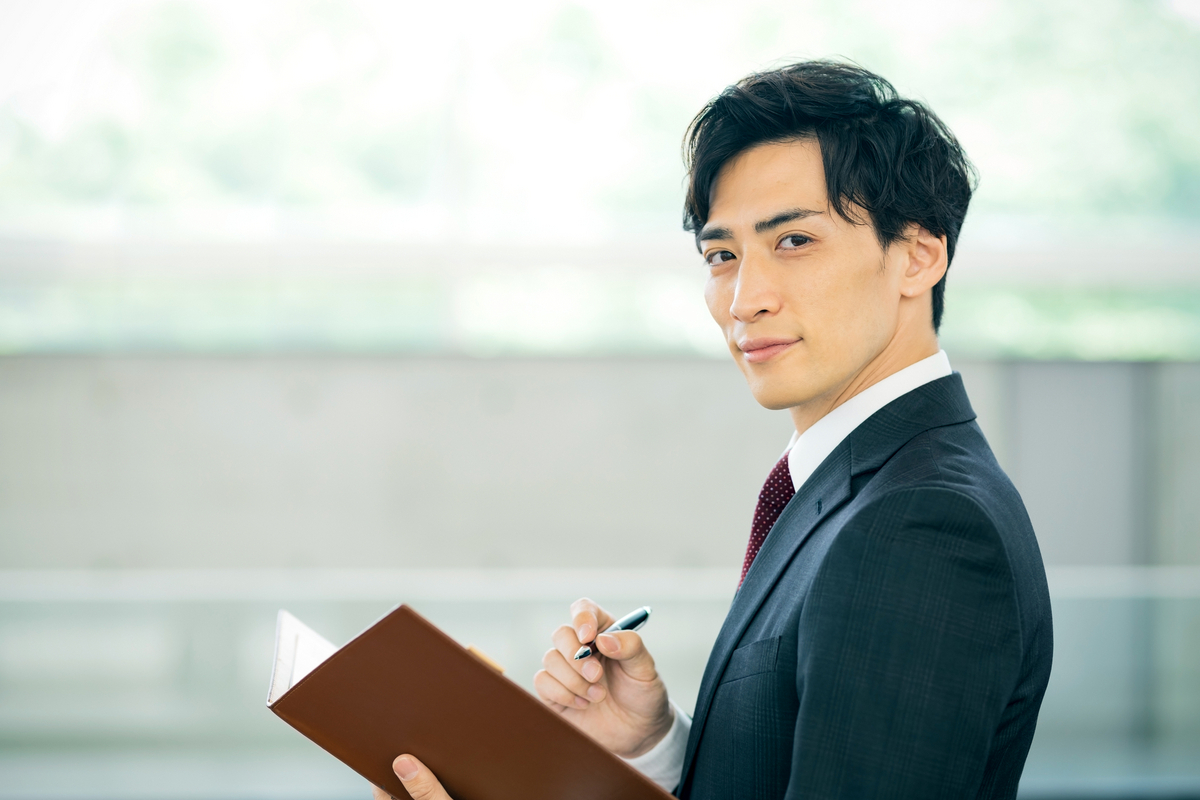手帳を手にする男性