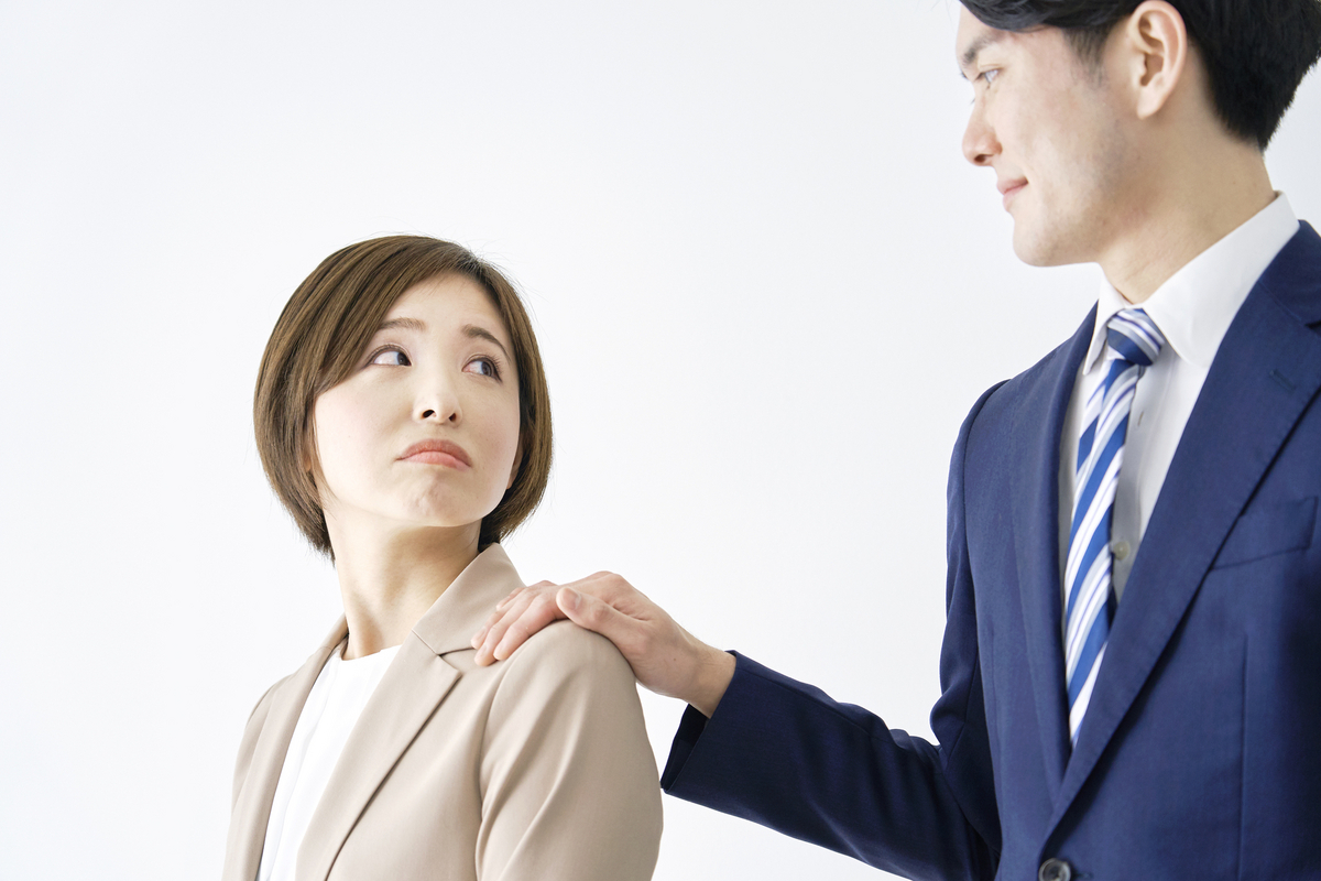 女性の肩に手を置く男性