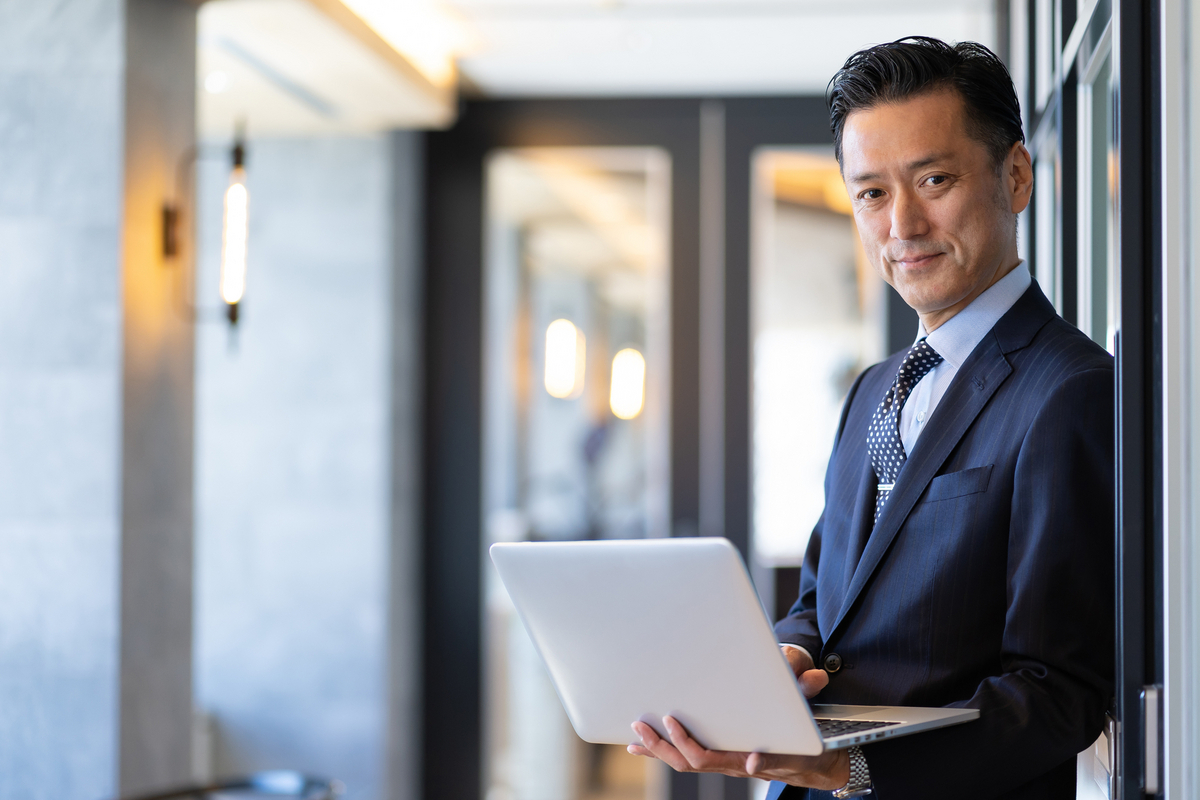 パソコンを手にしている男性
