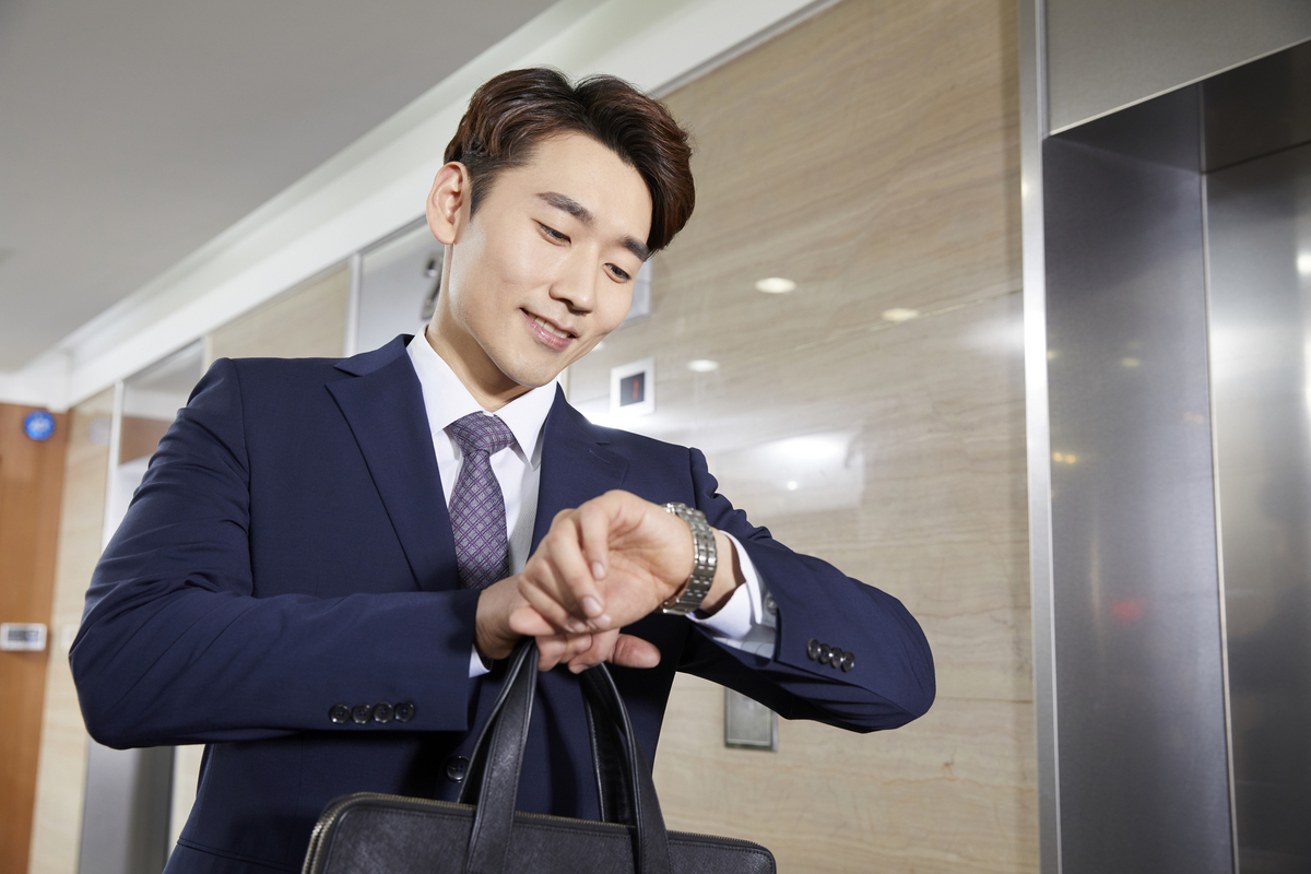 腕時計を見る男性ビジネスマン